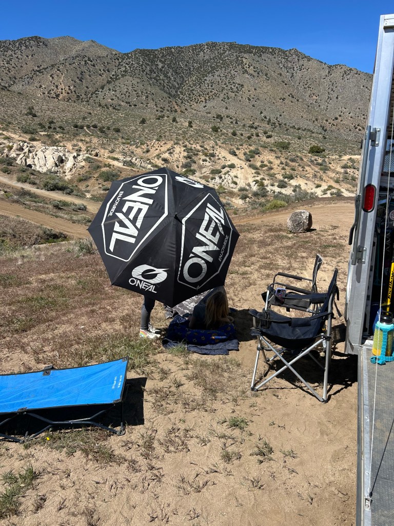 Camp setup with O'Neal umbrella and mountains in background